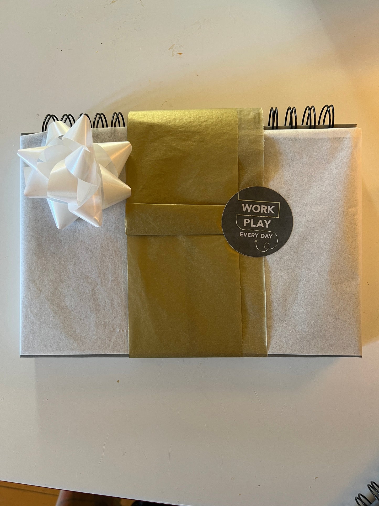 gift wrapped planner in white and gold tissue paper (bow pictured but not included in packages)