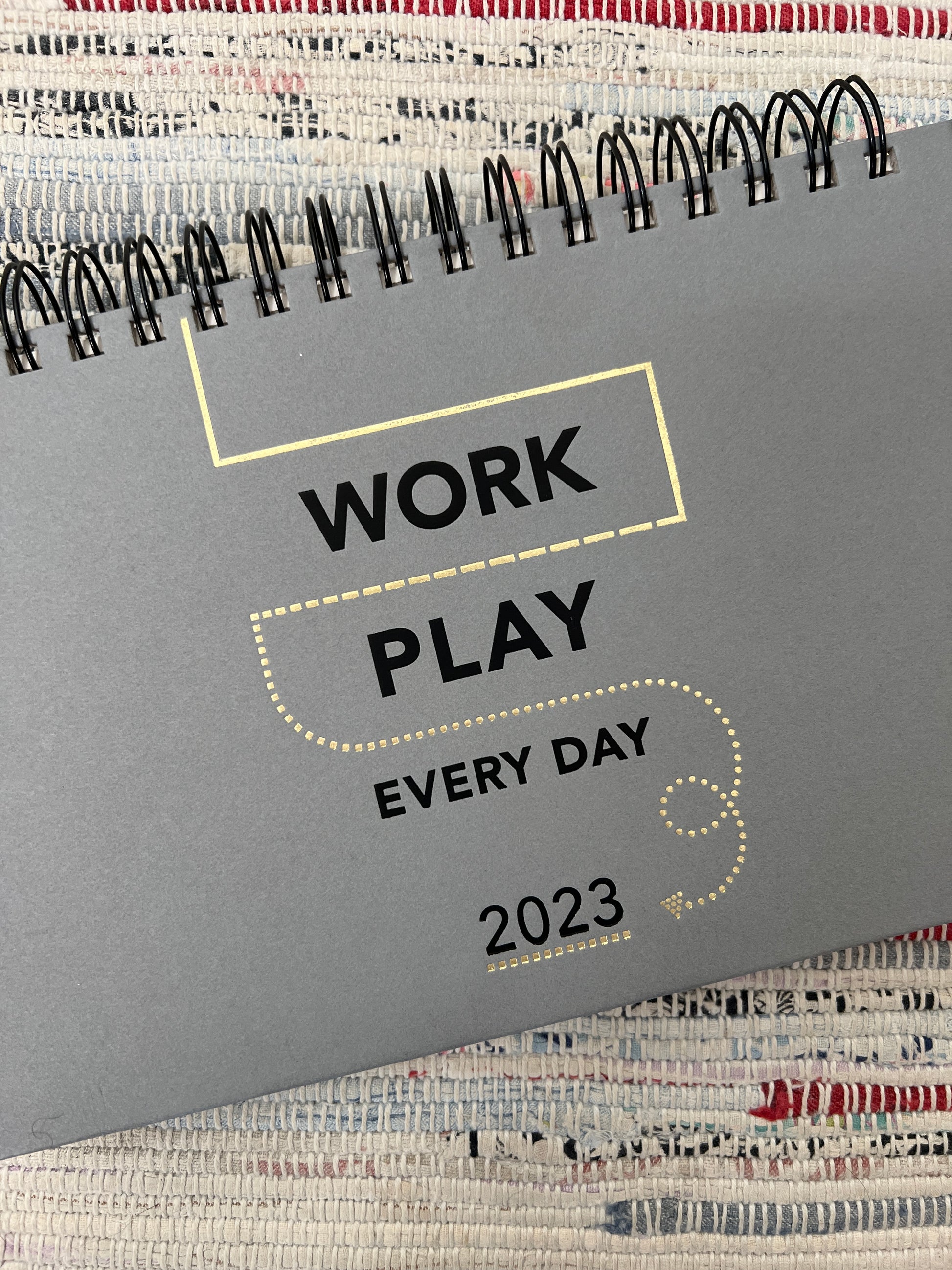 Work Play Every Day planner on a rag rug